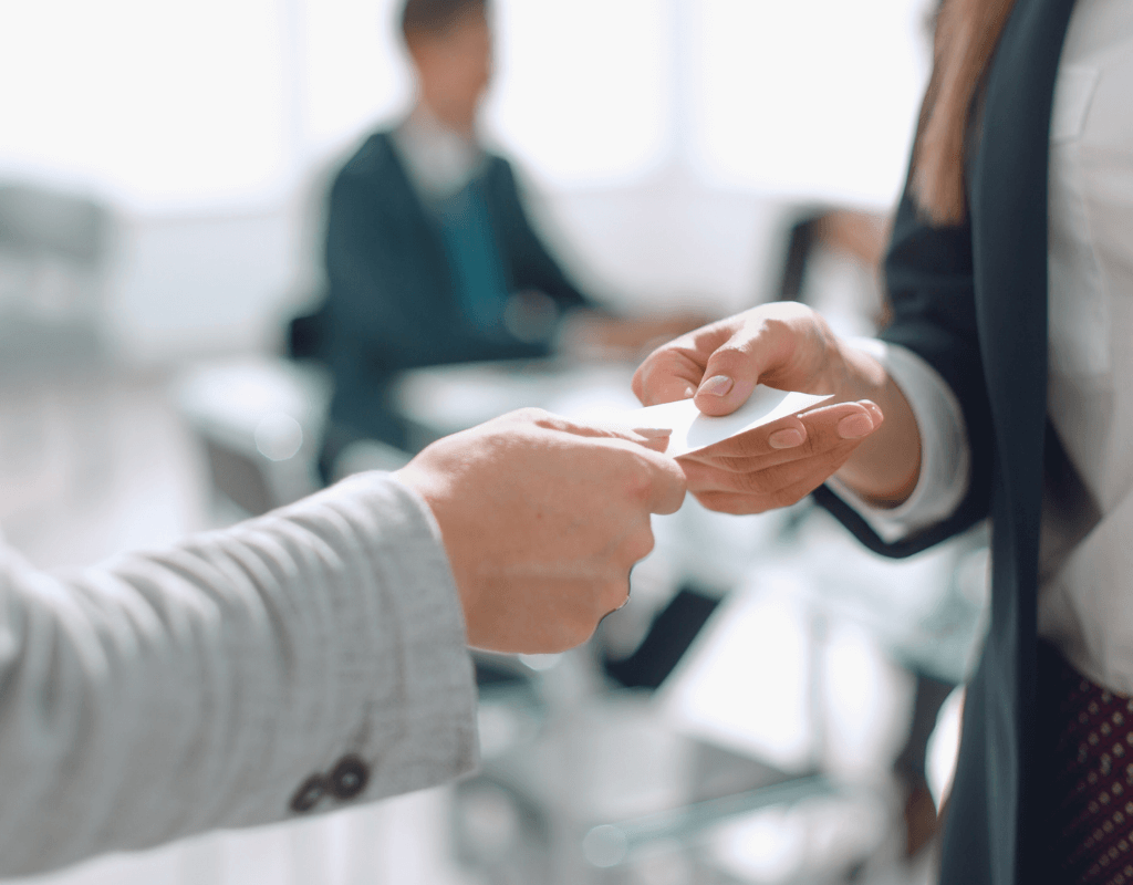 a person handing over a business card with one hand