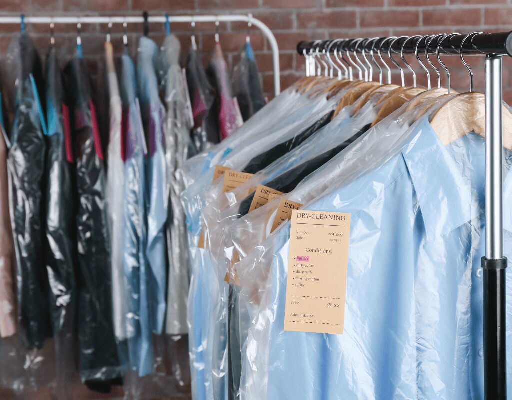 a row of clothes in plastic bags at Dry Cleaning Store