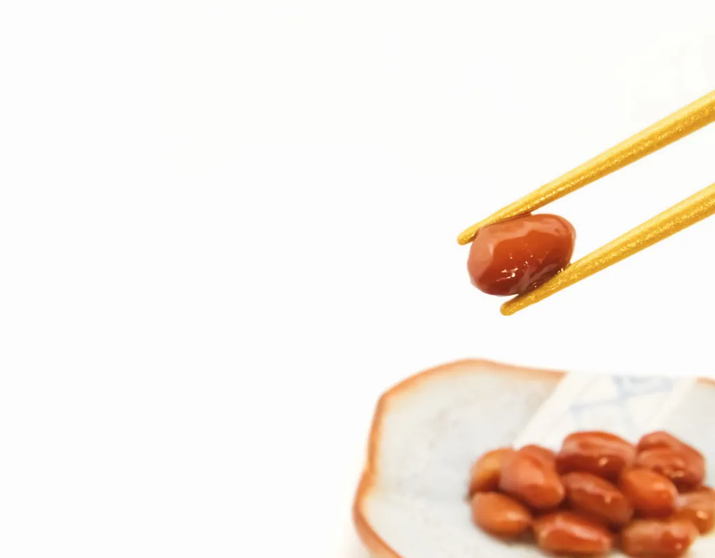 a pair of chopsticks holding a bean
