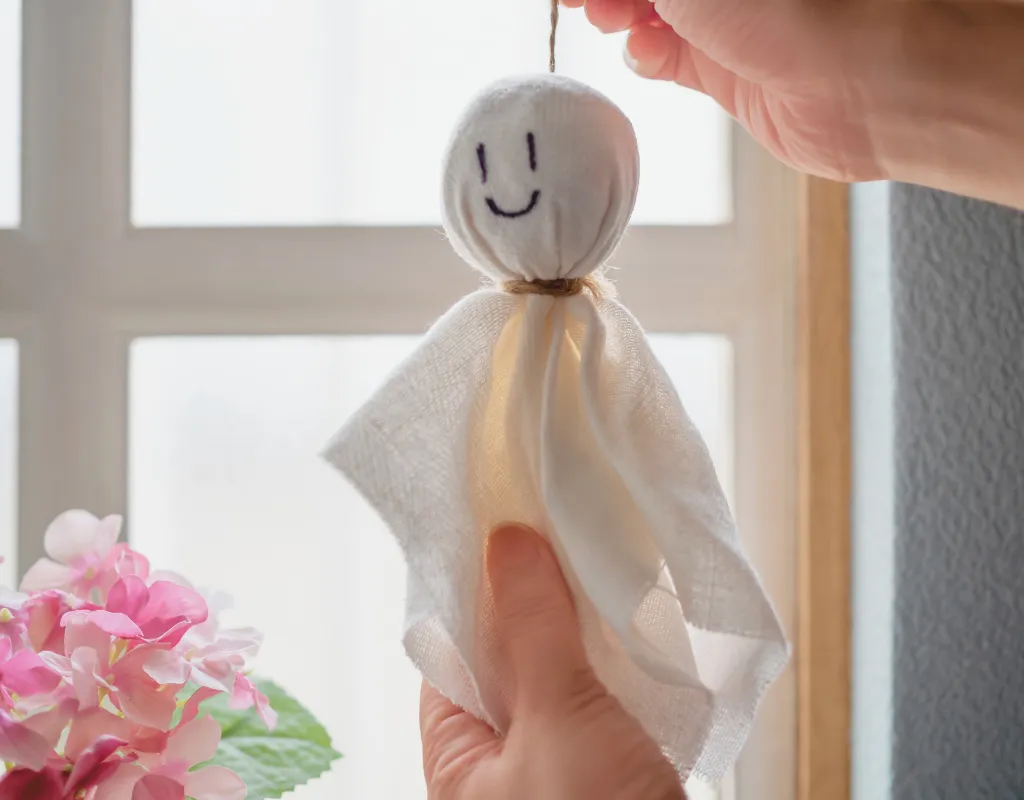 a person holding a teru teru bozu