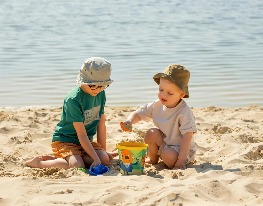 two children playing with sand on a beach
