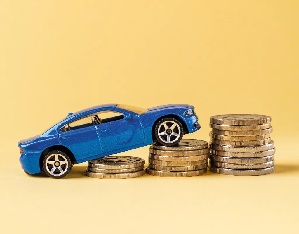 a blue car on top of stacks of coins